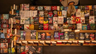 Mesa de novedades de una librería con una clienta mirando libros