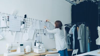 Diseñadora de una marca de ropa revisando bocetos en su taller