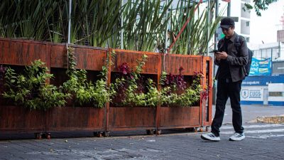 App que paga por caminar: hombre caminando por la calle con el móvil