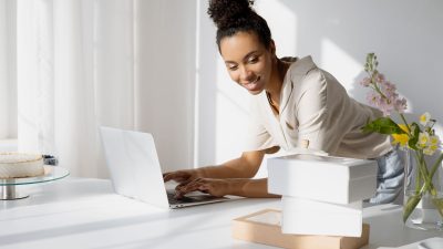 Emprendedora gestionando su negocio online desde casa con el portátil