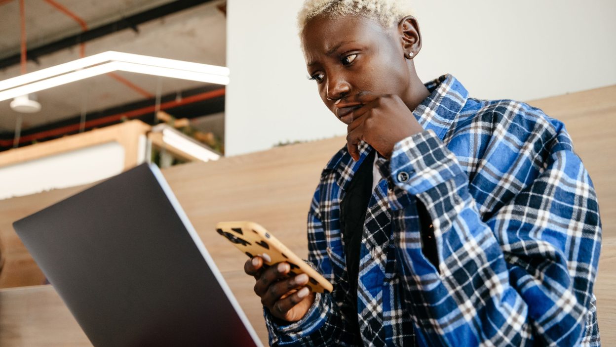 Persona leyendo con duda una oferta de trabajo por WhatsApp en el móvil