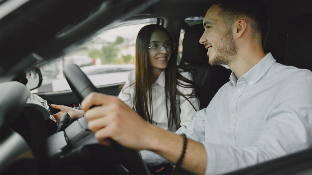 Dos compañeros de trabajo compartiendo coche de camino a la oficina