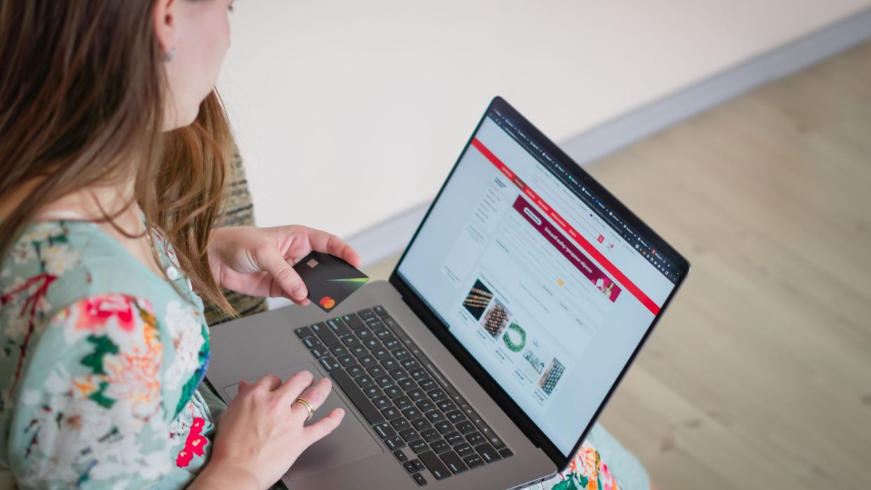 Mujer comprando por internet con el portátil y la tarjeta